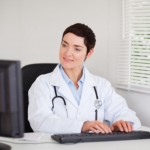 Doctor typing on computer: SEO Medical Medical Web Copywriting Blog